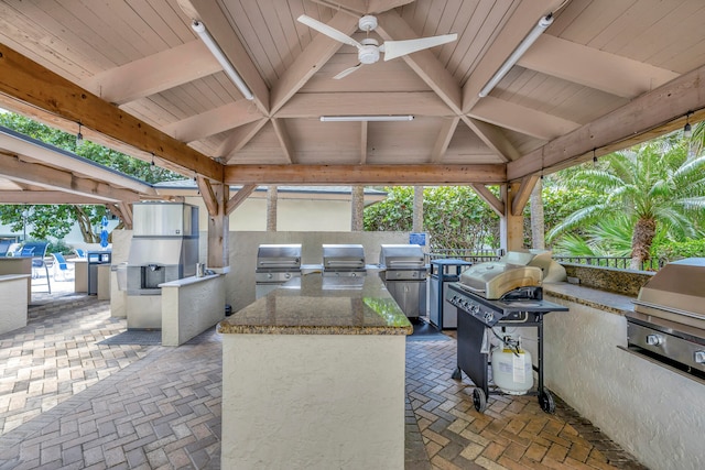 view of patio with exterior kitchen, area for grilling, a gazebo, and ceiling fan