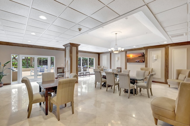 tiled dining space featuring plenty of natural light, a chandelier, ornate columns, and a paneled ceiling