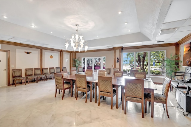 tiled dining area with a raised ceiling, an inviting chandelier, crown molding, and plenty of natural light