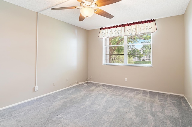 carpeted spare room featuring ceiling fan and a textured ceiling