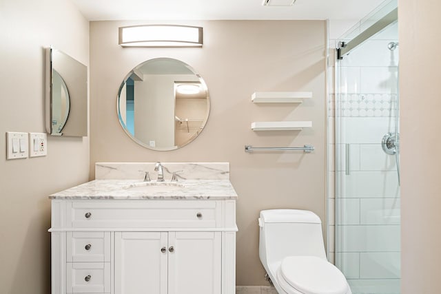 bathroom featuring vanity, toilet, and a shower with door