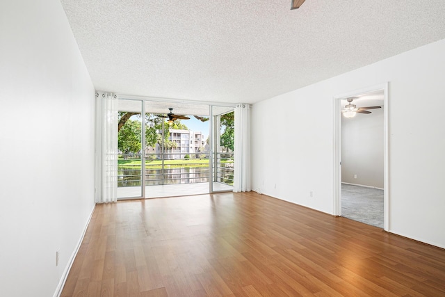 unfurnished room featuring wood-type flooring, a textured ceiling, and expansive windows