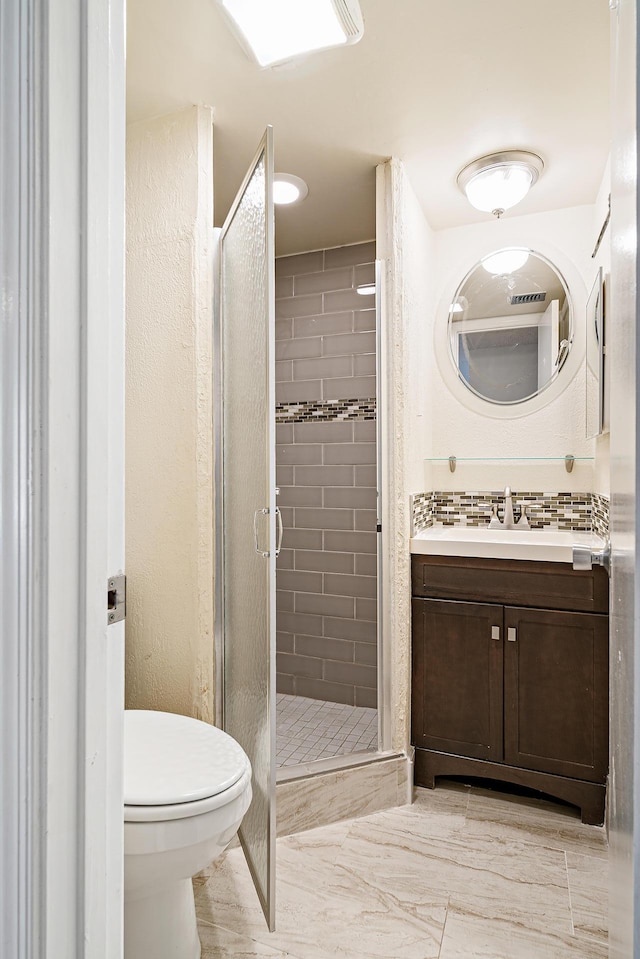 bathroom featuring vanity, toilet, and an enclosed shower