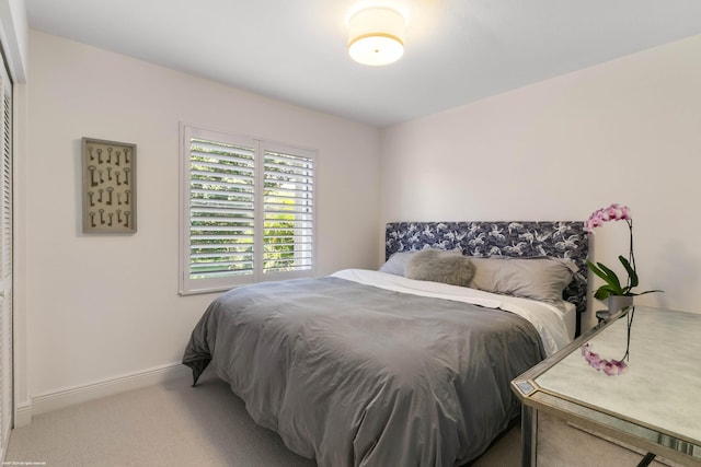 bedroom featuring light carpet and baseboards