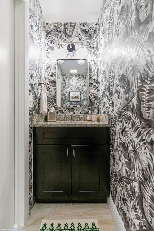 bathroom with wallpapered walls and vanity