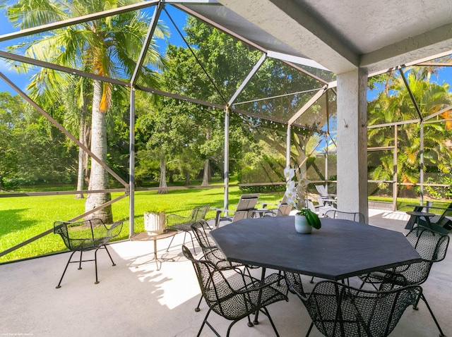 view of patio / terrace featuring glass enclosure and outdoor dining area