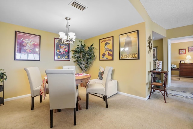 dining space featuring light carpet and an inviting chandelier