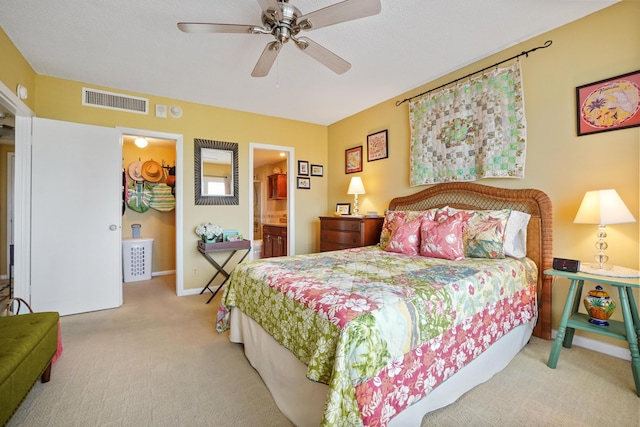 bedroom with ensuite bathroom, ceiling fan, and light carpet