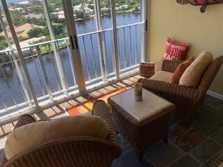 sunroom featuring a water view