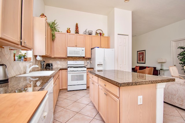 kitchen featuring white appliances, sink, light brown cabinets, light tile patterned floors, and a kitchen island