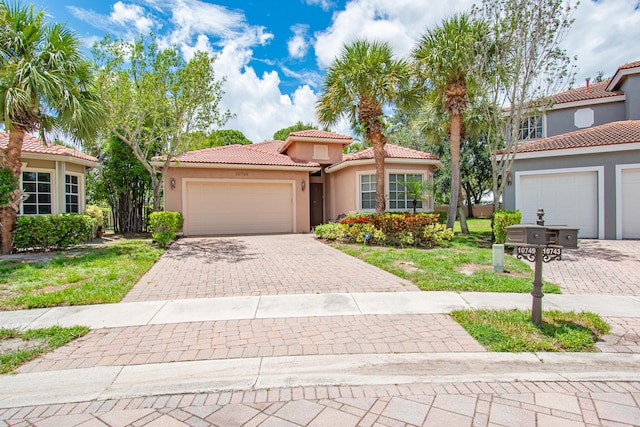 mediterranean / spanish house featuring a front lawn and a garage