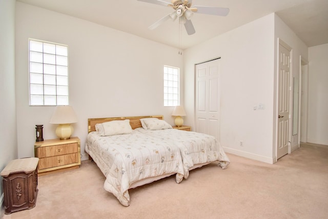 bedroom featuring ceiling fan, a closet, and light colored carpet