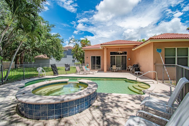 view of swimming pool with ceiling fan, an in ground hot tub, and a patio