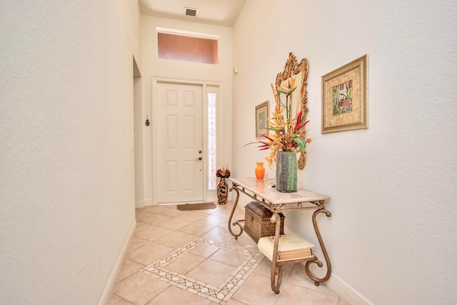 foyer featuring a towering ceiling and light tile patterned floors