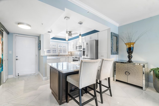 kitchen featuring white cabinetry, tasteful backsplash, stainless steel appliances, hanging light fixtures, and crown molding