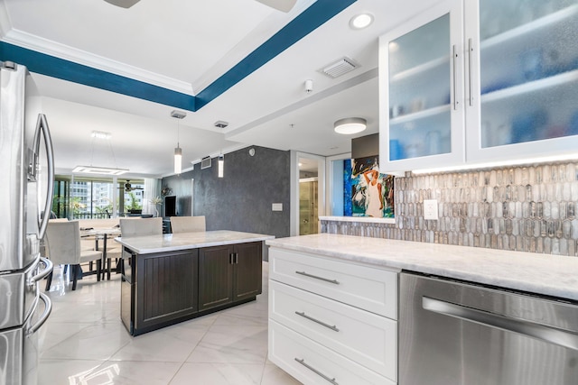 kitchen with white cabinetry, appliances with stainless steel finishes, light stone counters, and backsplash