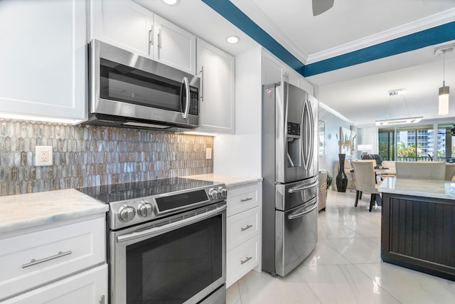 kitchen featuring pendant lighting, stainless steel appliances, tasteful backsplash, ornamental molding, and white cabinets