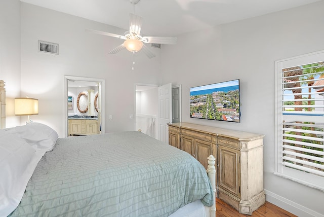 bedroom featuring connected bathroom, hardwood / wood-style floors, and ceiling fan