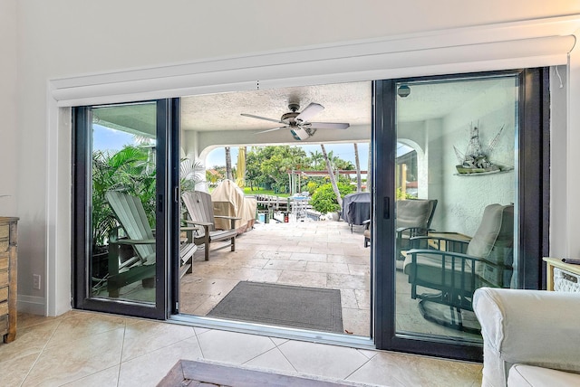 doorway with light tile patterned flooring and ceiling fan