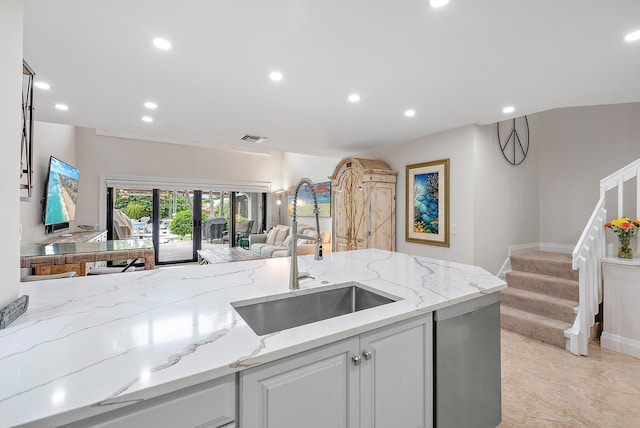 kitchen featuring white cabinetry, light tile patterned floors, light stone countertops, and sink