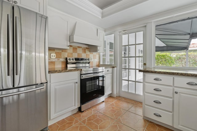 kitchen with tasteful backsplash, white cabinets, custom exhaust hood, stainless steel appliances, and crown molding