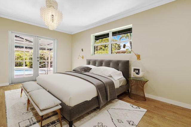 bedroom featuring access to exterior, a chandelier, ornamental molding, and light hardwood / wood-style floors