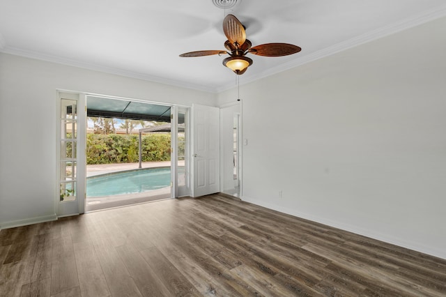 empty room with baseboards, ceiling fan, dark wood-type flooring, and crown molding