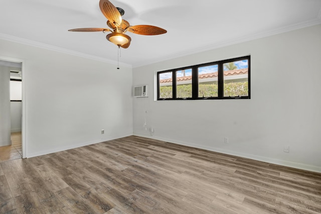 spare room featuring crown molding, baseboards, and wood finished floors