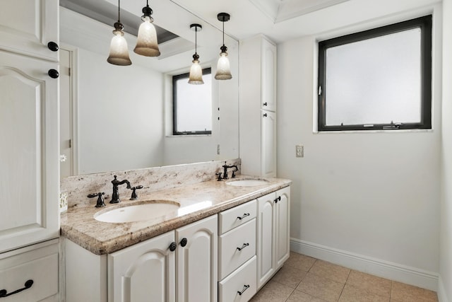 full bath with baseboards, double vanity, a sink, and tile patterned floors