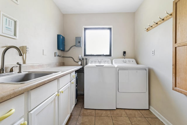 washroom featuring cabinets, light tile patterned floors, sink, and washing machine and dryer