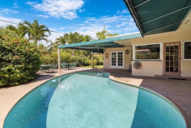 view of swimming pool featuring french doors and a patio