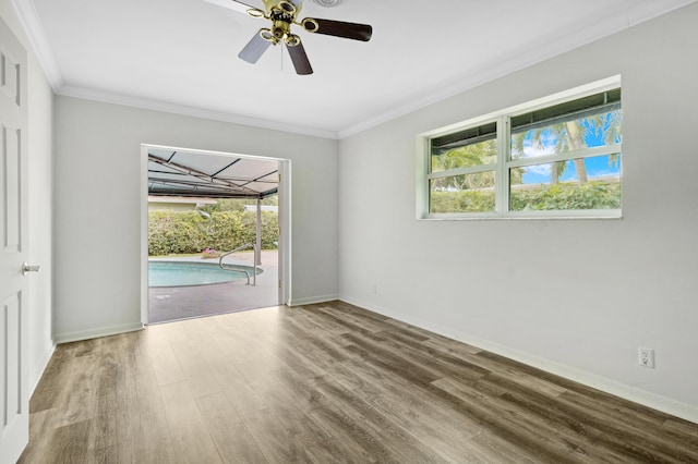 unfurnished room with crown molding, a ceiling fan, a sunroom, wood finished floors, and baseboards