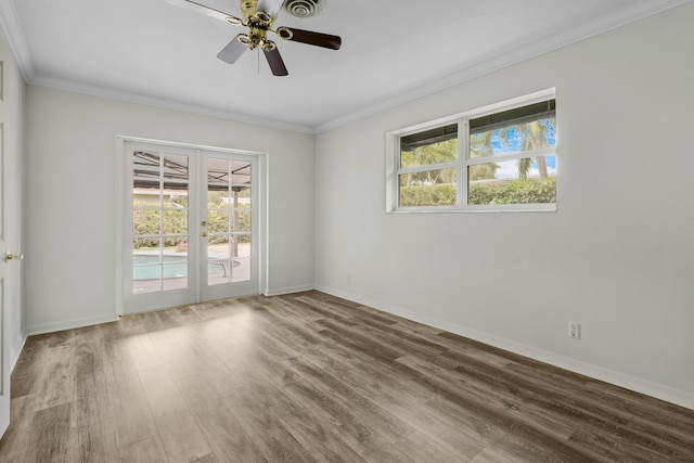 empty room featuring ornamental molding, french doors, wood finished floors, and baseboards