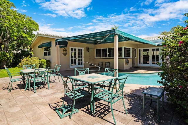 view of swimming pool with a patio and french doors