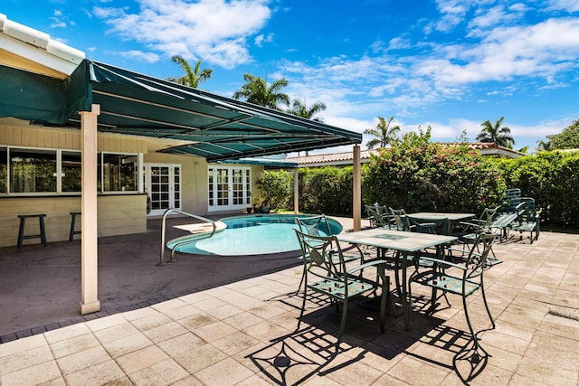 view of swimming pool featuring french doors and a patio