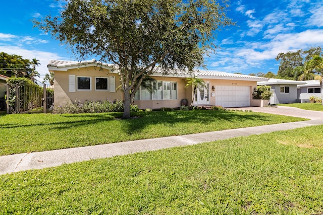 ranch-style home featuring a garage and a front lawn