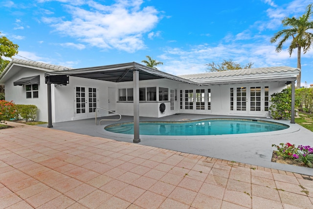 outdoor pool with a patio and french doors