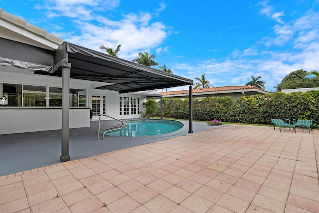 outdoor pool with french doors and a patio area