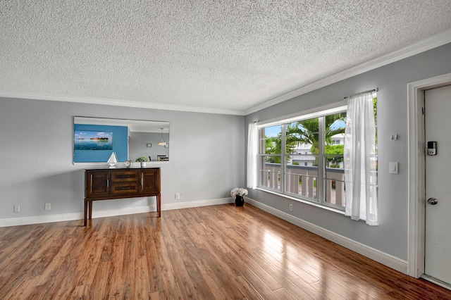 living room featuring wood-type flooring, ornamental molding, and a textured ceiling