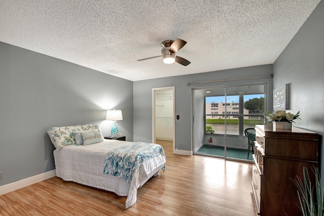 bedroom with ceiling fan, a closet, a textured ceiling, and light wood-type flooring