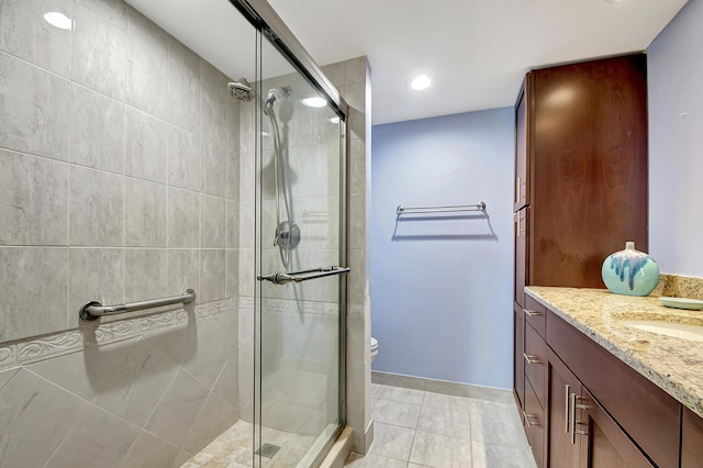 bathroom with vanity, toilet, an enclosed shower, and tile patterned flooring