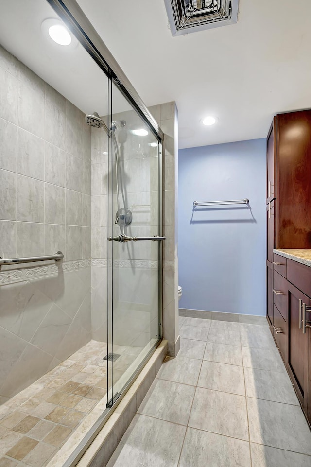 bathroom with vanity, toilet, tile patterned flooring, and a shower with door