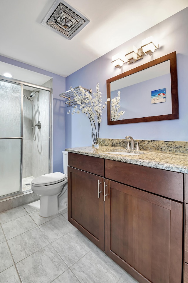 bathroom featuring tile flooring, a shower with shower door, toilet, and vanity