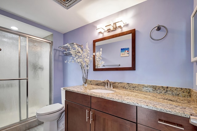 bathroom featuring vanity with extensive cabinet space, an enclosed shower, and toilet