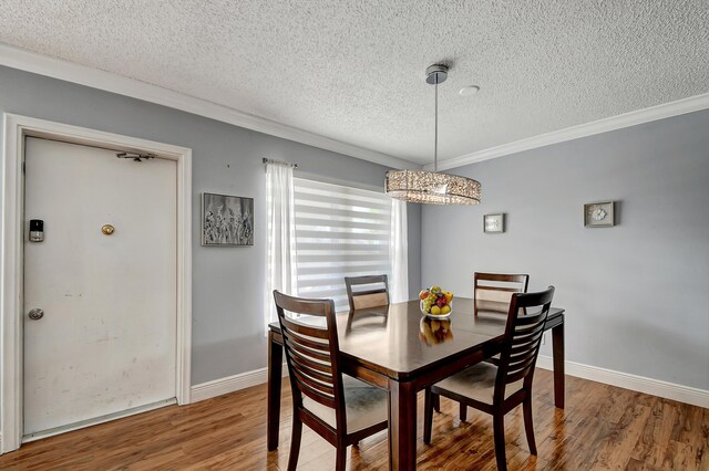 dining space featuring crown molding, hardwood / wood-style flooring, and a textured ceiling