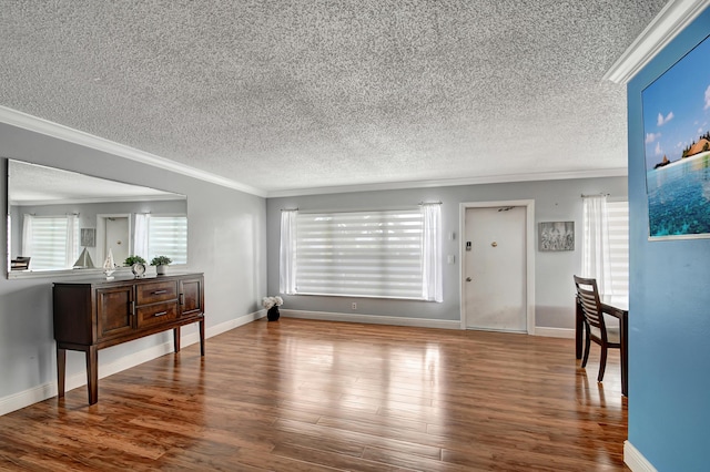 interior space featuring wood-type flooring, a textured ceiling, and crown molding