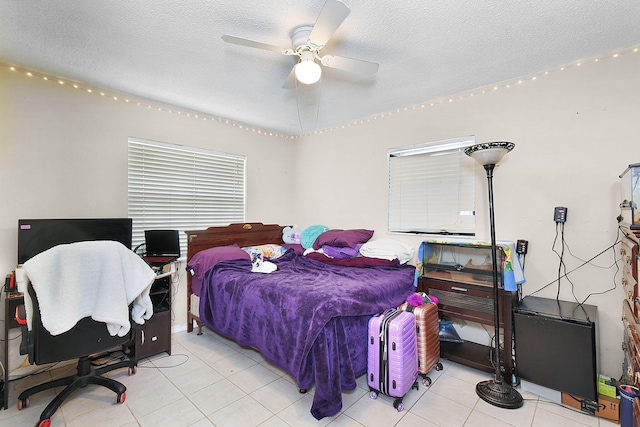 tiled bedroom featuring ceiling fan and a textured ceiling