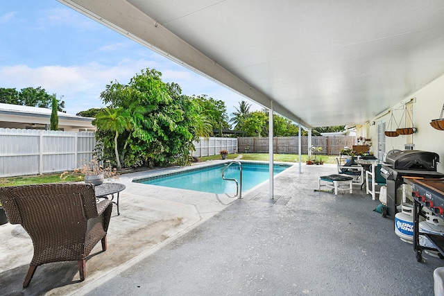 view of swimming pool featuring a grill and a patio area