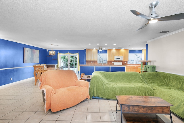 living room with ceiling fan, plenty of natural light, crown molding, and light tile patterned flooring