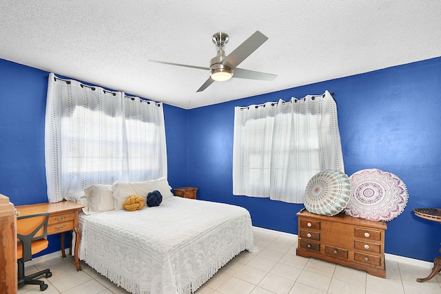 tiled bedroom with multiple windows, a textured ceiling, and ceiling fan